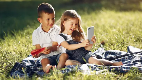 Dos ni&ntilde;os peque&ntilde;os juegan con un m&oacute;vil