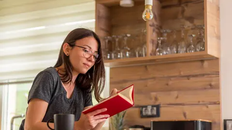 chica leyendo en una cafeter&iacute;a