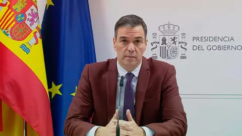 Pedro S&aacute;nchez sentado delante de las banderas de Espa&ntilde;a y la UE