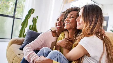 Varias amigas abrazadas y sonriendo