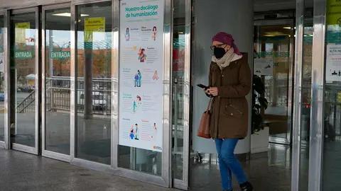 Una persona sale de un centro hospitalario con mascarill