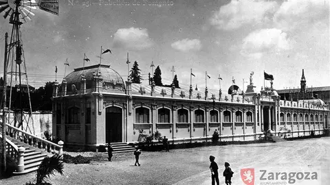Pabell&oacute;n de Fomento y "motor de aire". Estudio Coyne. AMZ_4-1_0003015. Al fondo, la que ser&aacute; Escuela de Artes y Oficios en su primera versi&oacute;n. El fot&oacute;grafo estar&iacute;a en la embocadura de la calle Sanclemente, y Fomento abarcaba la plaza en todo su ancho