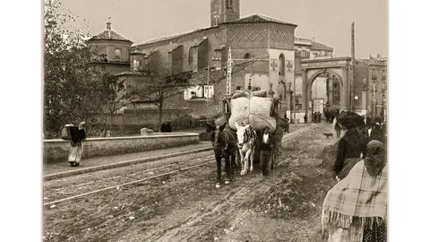 Puente sobre el Huerva, lugar de tr&aacute;nsito habitual para entrar y salir de Zaragoza atravesando las huertas cercanas de Montemol&iacute;n, Las Fuentes y pueblos del Bajo Arag&oacute;n. Al fondo de la imagen, la desaparecida Puerta dedicada al general Baldomero Espartero, duque de la Victoria; y a la izquierda, la iglesia de San Miguel de la Huerva o de los Navarros con su torre y campana de los perdidos. Ca. 1906. Archivo M&ordf; Pilar Bernad Arilla para Anteayer Fotogr&aacute;fico Zaragozano