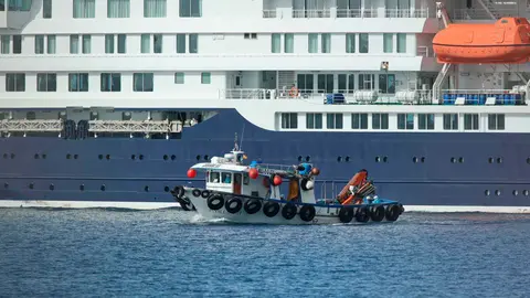 Varios pasajeros abandonan el barco en una lancha | Foto de Ministerio de Sanidad