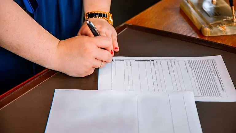 Mujer firmando documentos laborales 