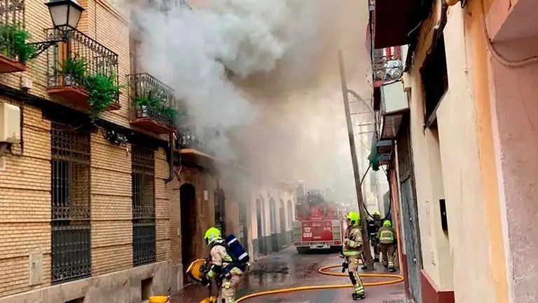 Bomberos apangando fuego en una vivienda