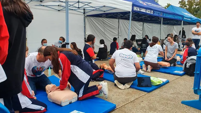 Foto de las carpas del taller de reanimaci&oacute;n cardiopulmonar con mucha gente aprendiendo