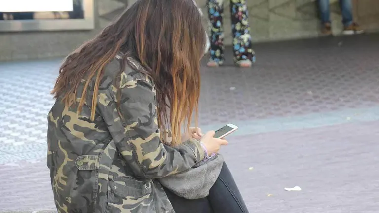 Chica sentada con su movil