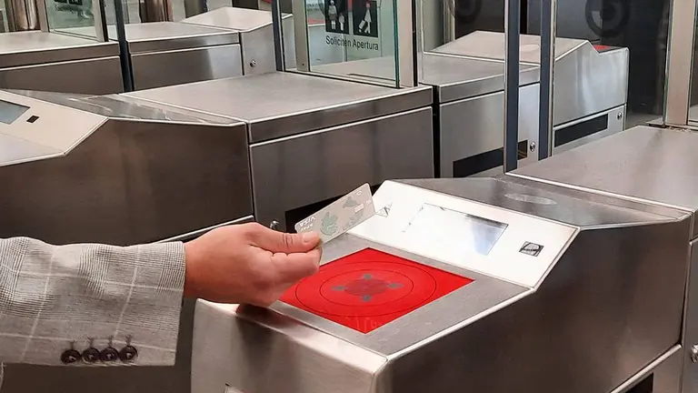 Mano que acerca tu tarjeta de cr&eacute;dito al torno de Renfe