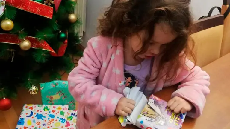 ni&ntilde;a abre los regalos de los reyes magos 