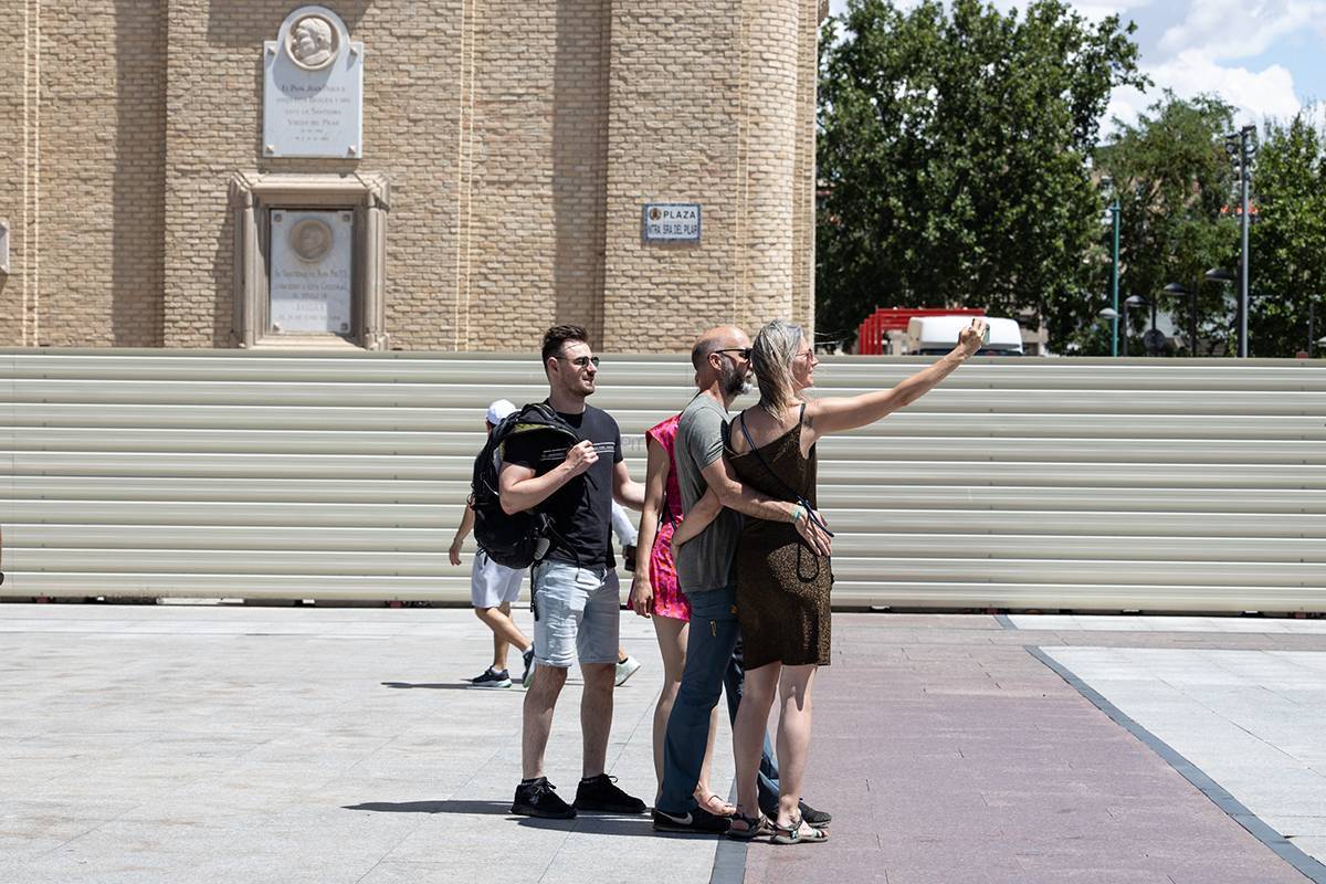 Turistas se hacen un selfie junto a una torre vallada del Pilar