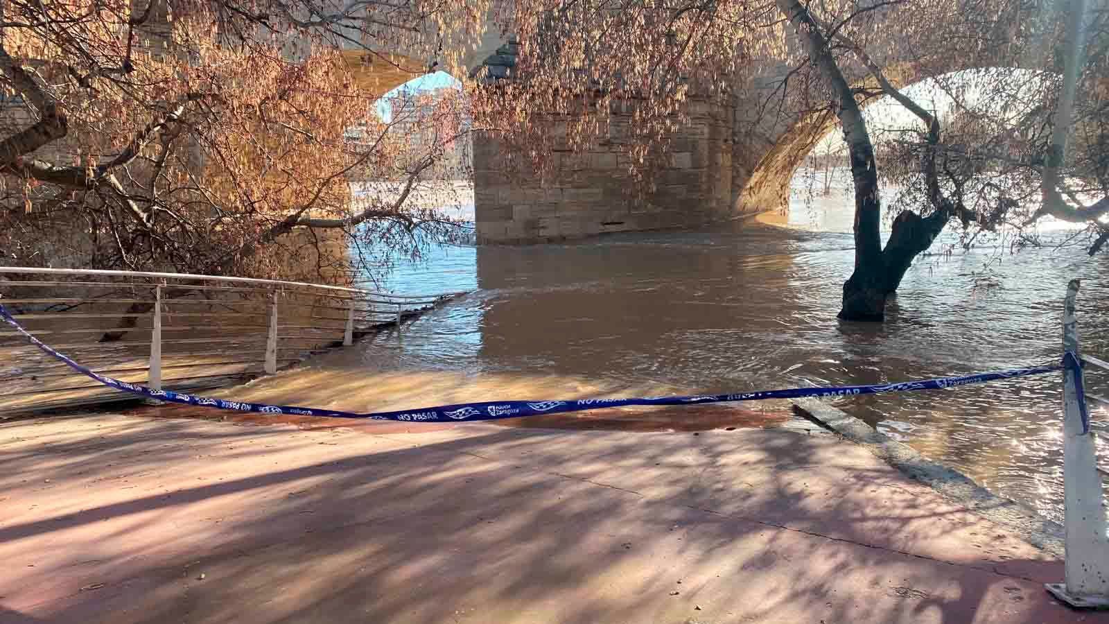 El agua ya llega a zonas de la ribera como la bajada del Club Náutico al Puente de Piedra.