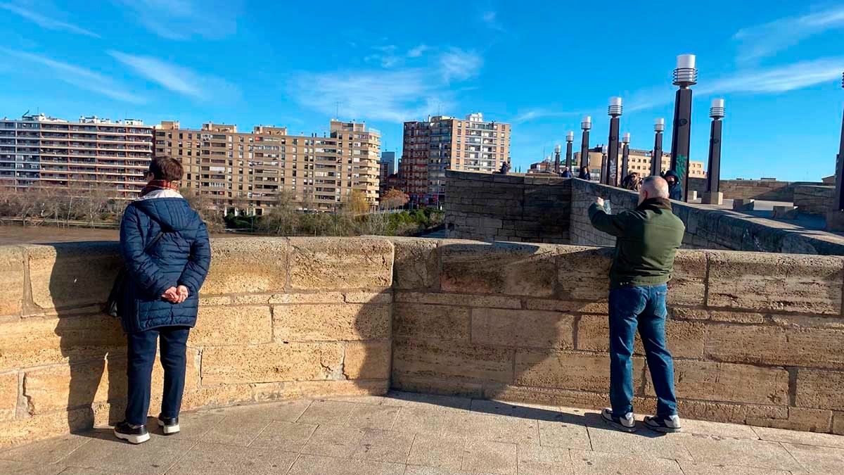 Los zaragozanos se han acercado a la ribera para inmortalizar la crecida del Ebro.