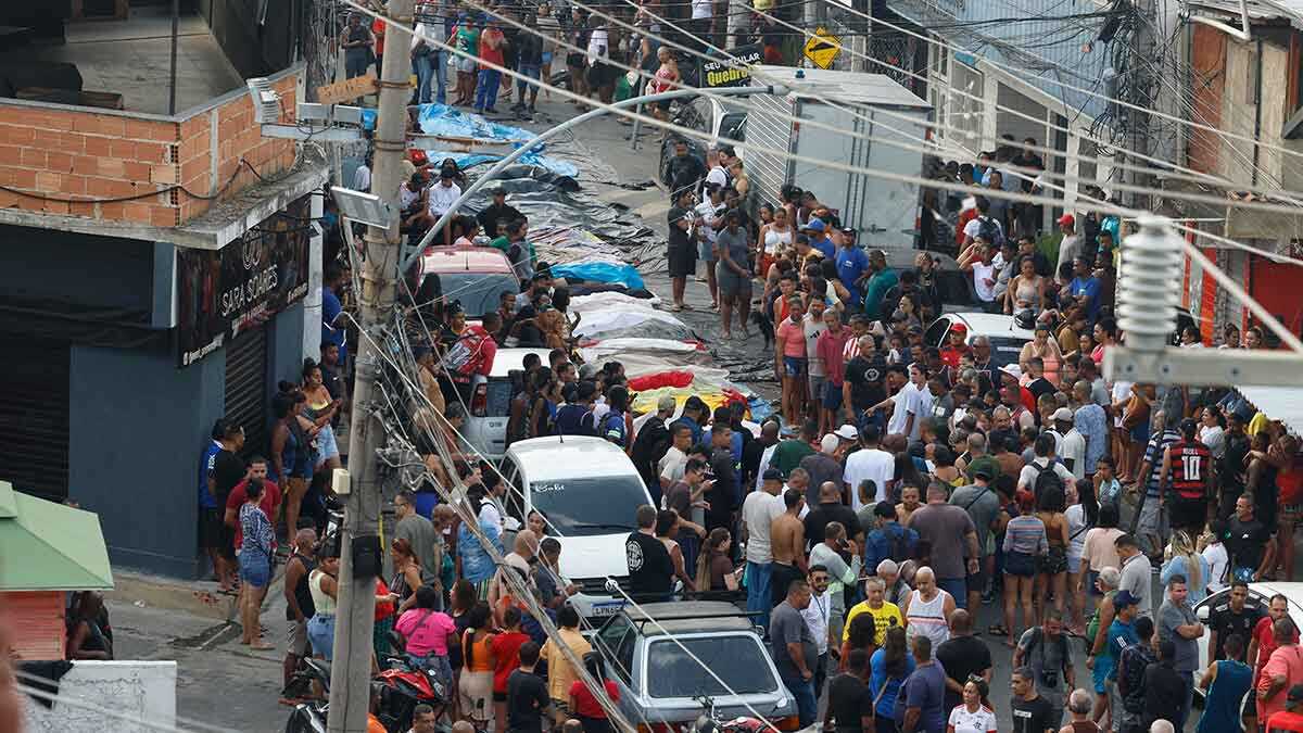 Personas observan cuerpos sin vida en una calle este miércoles, en Río de Janeiro (Brasil). EFE/ Antonio Lacerda