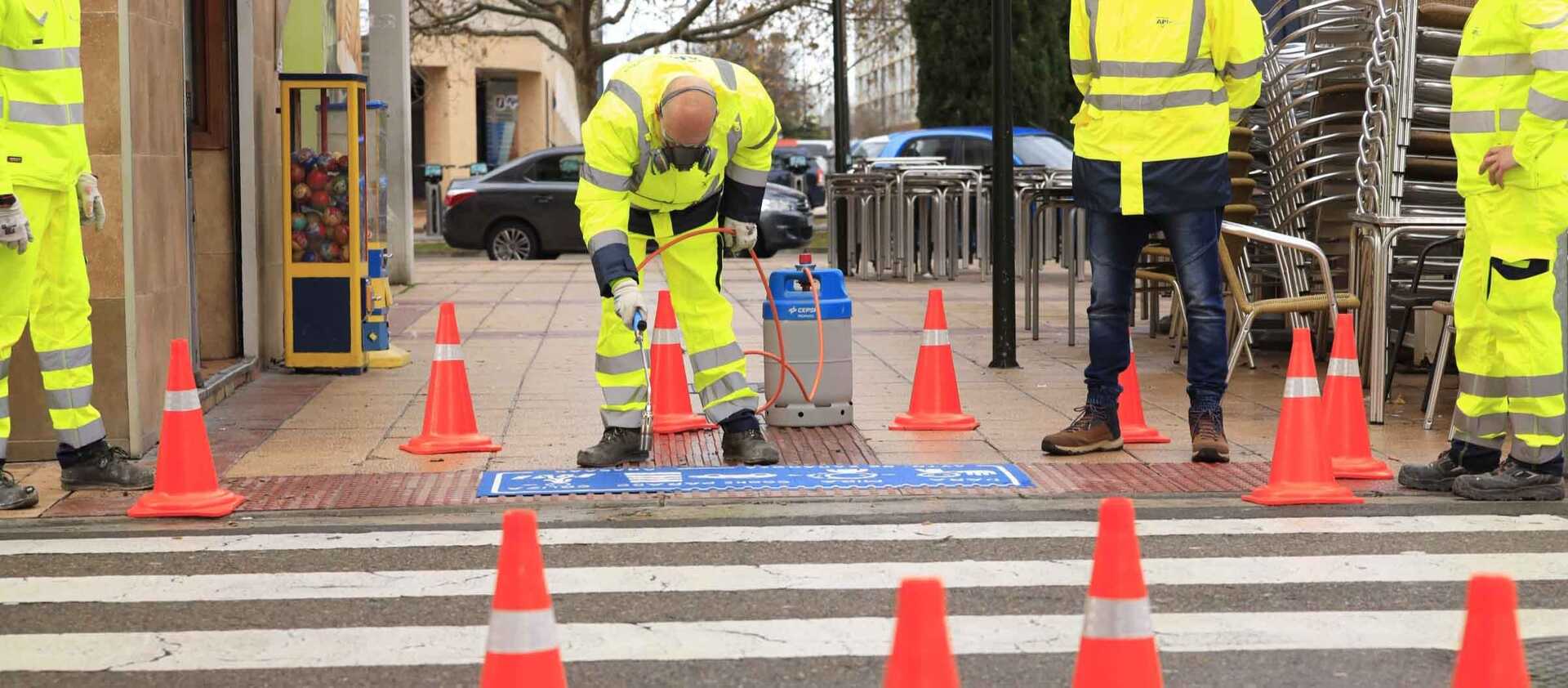 Operarios trabajando junto a los pasos de peatones